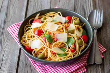 Domatesli spagetti makarna, fesleğen, zeytin ve parmesan peyniri. Sağlıklı beslenme. Vejetaryen yemeği.
