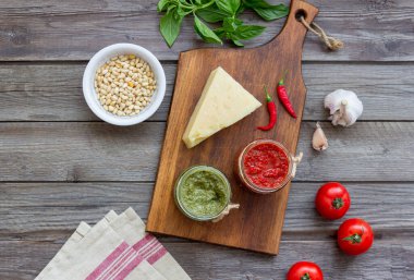 Kırmızı pesto ve fesleğen soslu iki cam kavanoz. Ulusal mutfak. Sağlıklı beslenme. Vejetaryen yemeği.