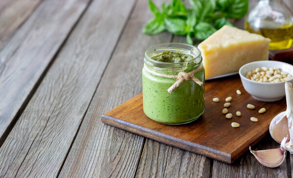 Italian pesto sauce on a wooden background. National kitchen. Healthy eating. Vegetarian food