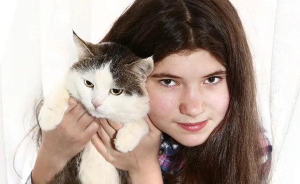 Девушка с длинными темными темными густыми волосами держит кота — стоковое фото