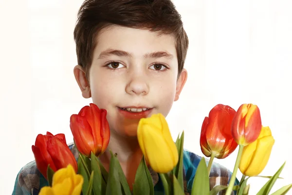 Preteen handsome boy with tulip flowers — 스톡 사진