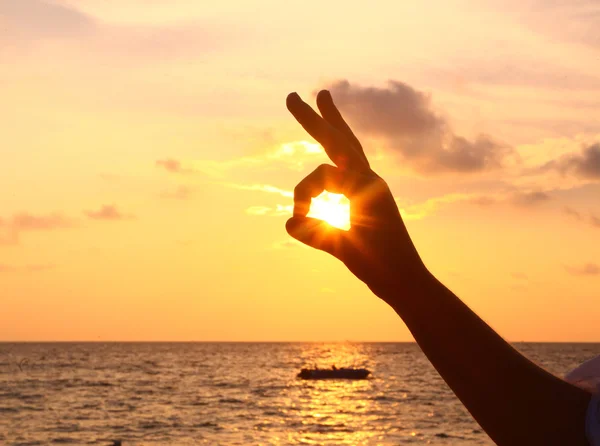 Fingers and sun eye on the sunset background — Stock Photo, Image