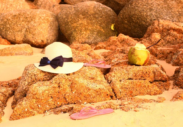 Chapéu de palha chinelos de coco na praia pedregosa — Fotografia de Stock