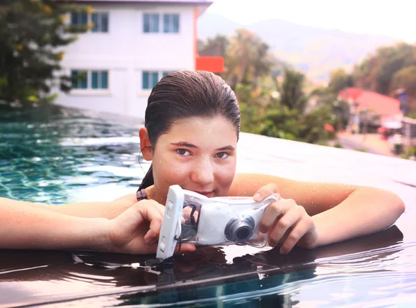 Menina na piscina com câmera subaquática — Fotografia de Stock