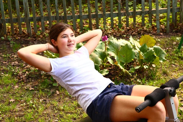 Adolescente menina bonita exercitar o estômago — Fotografia de Stock