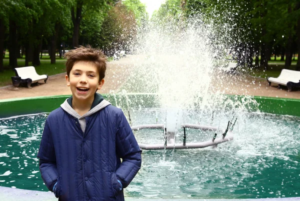 Boy in the park on fountain background — Stock Photo, Image