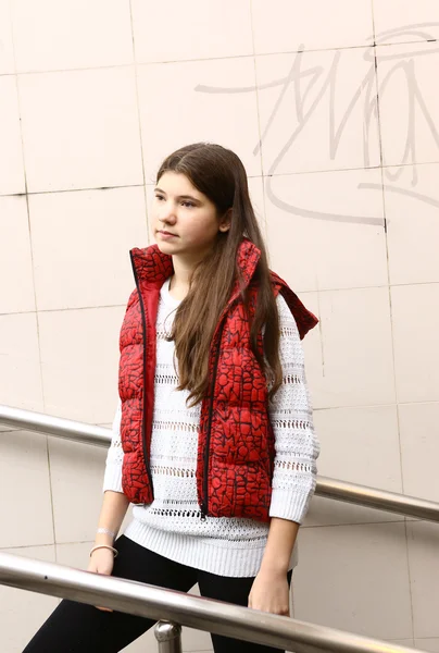 Chica con el pelo castaño largo en chaleco rojo abajo — Foto de Stock