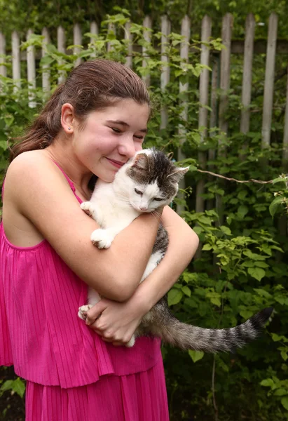 Een bonita chica en rosa vestido abrazo siberiano gato —  Fotos de Stock