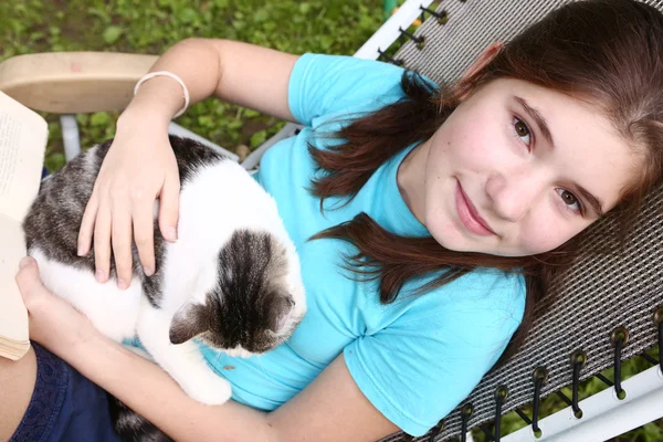 Chica en cubierta silla con libro y gato —  Fotos de Stock
