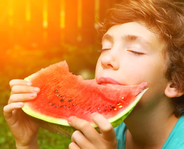 Preteen pojke bita vatten melon slice — Stockfoto