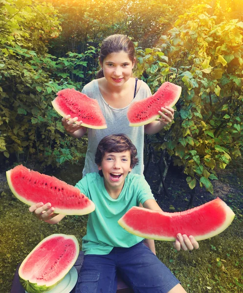 Menino e menina adolescente se divertir comendo melão de água — Fotografia de Stock