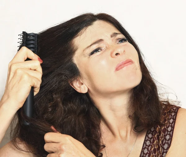 Красивая молодая женщина с расчёской, застрявшая в волосах — стоковое фото