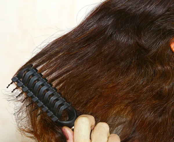 Brązowe włosy są czesane zbliżenie zdjęcie — Zdjęcie stockowe