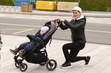 Moskova, Rusya, 30 Ekim 2020: Çocuklu tanımlanamayan kadınlar Moskova 'daki şehir parkında eğitmenle bebek arabaları eğitimi alıyorlar.