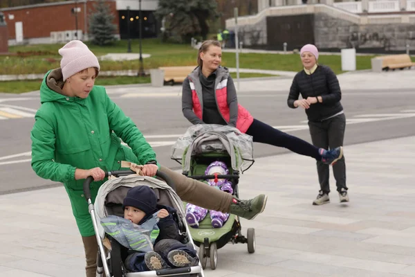 2020年10月30日 俄罗斯莫斯科 一名身份不明的带着孩子的妇女在莫斯科的城市公园里与指导员一起上婴儿期健身课 — 图库照片