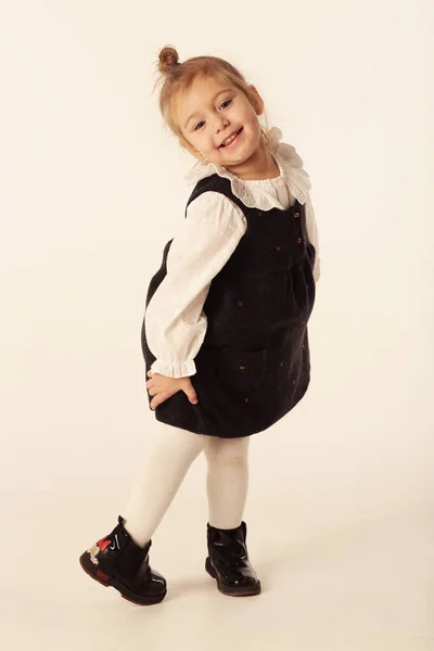 Mignonne petite fille blonde en robe noire pleine photo du corps isolé sur blanc — Photo