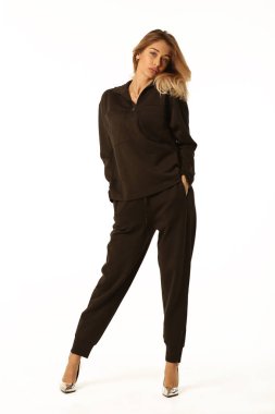 Siyah takım elbiseli sarışın genç kadın. Beyaz tenli vücut portresi.