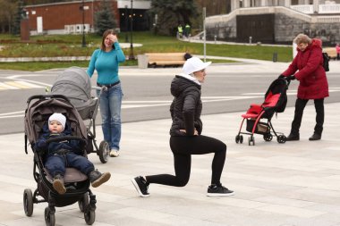 Moskova, Rusya, 30 Ekim 2020: Çocuklu tanımlanamayan kadınlar Moskova 'daki şehir parkında eğitmenle bebek arabaları eğitimi alıyorlar.