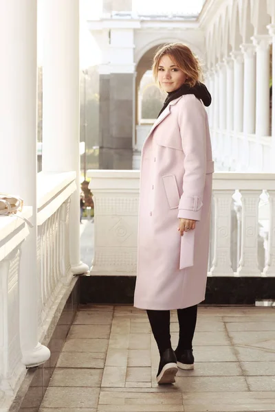 분홍색 코트와 가방을 금발의 사업가가 주변의 건물에 — 스톡 사진