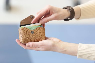 Deri kartvizit tutucu alışveriş merkezinin arka planında insan eliyle çekilmiş bir fotoğrafı kapat