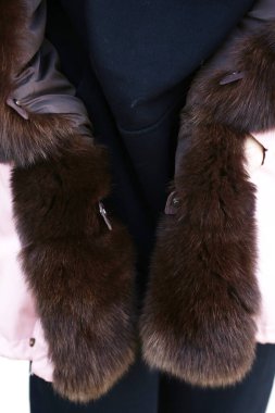  Şafak ceketli kadın kürk yakalı kapüşonlu. Şehir parkının arka planında yakın plan fotoğrafı.