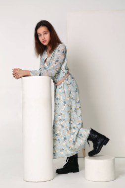 Yazlık baskılı elbiseli manken kız ve siyah botlu. Beyaz üzerine izole edilmiş vücut portresi.