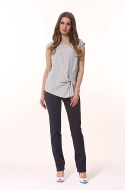 Beyaz pantolon ve çizgili bluzla poz veren iş kadını yönetici. Beyaz üzerinde izole edilmiş uzun bir fotoğraf. 