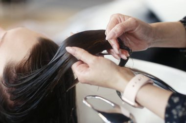 Kuaför müşterinin saçlarını yıkıyor. Kuaförde fotoğraf çektiriyoruz.