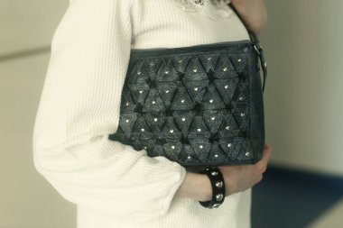 blue leather bag and bracelet close up photo with human hands 