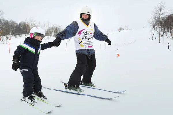 Alpin skidåkning master klass för barn med instruktör i vintersport skola för barn. — Stockfoto