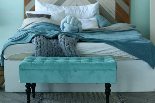Dormitorio esquina azul malo, trapo de punto, almohadas y banco de cerca foto — Foto de Stock