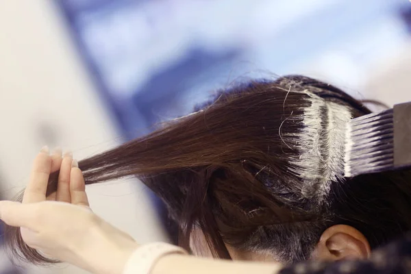 Mano de peluquero con tinte para el cabello haciendo corte de pelo y coloración del cabello en la foto de primer plano del cliente —  Fotos de Stock