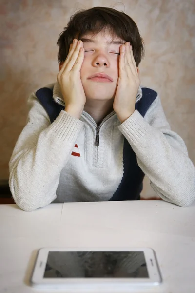 Chico con almohadilla cansado y tiene dolor de cabeza — Foto de Stock