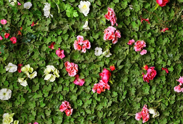Hecke mit Plüsch, Blumen und hölzerner Gier lizenzfreie Stockbilder