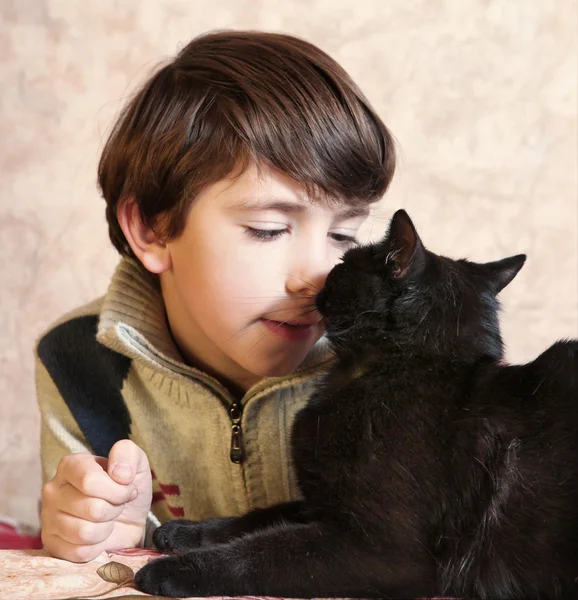 可爱的青春期男孩与黑猫在桌子上 — 图库照片