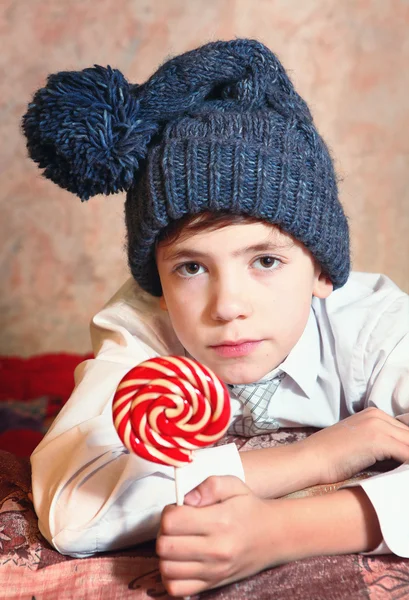 Schattige preteen jongen in blauwe gebreide muts met rode en witte ronde ca — Stockfoto