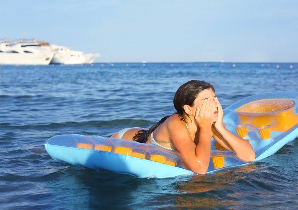 Frühchen Mädchen im Badeanzug mit aufblasbarer Matratze auf dem blu — Stockfoto