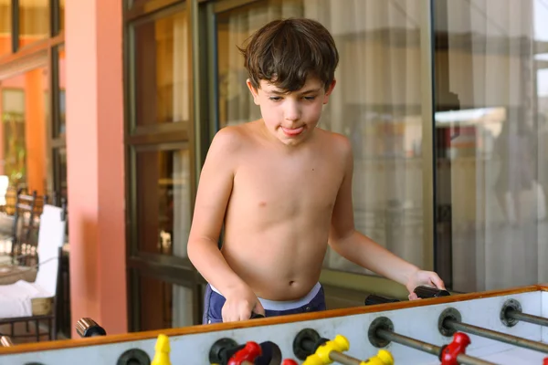 Handsome preteen boy play table soccer in beach resort hotel rec — Stock Photo, Image