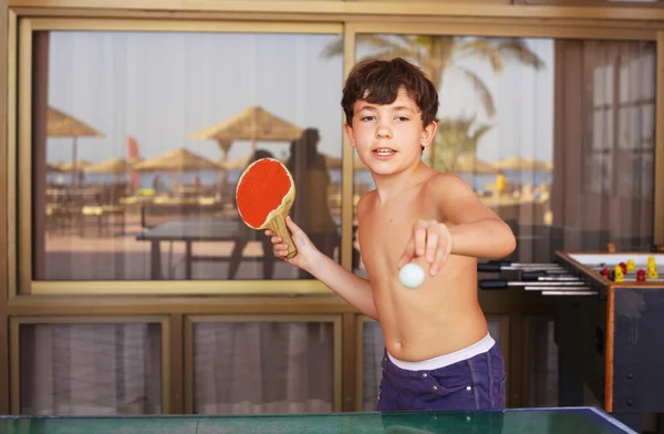 Preadolescente guapo chico jugar tenis de mesa en la playa resort hotel —  Fotos de Stock