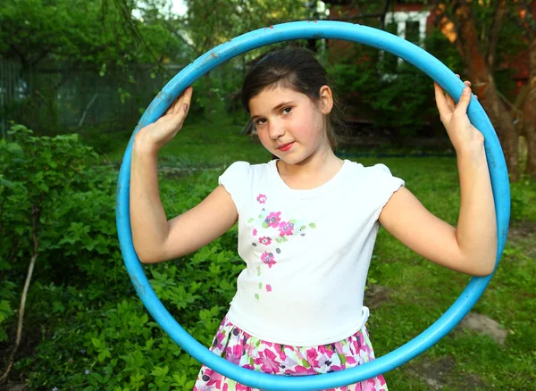 Preadolescente hermosa chica con hula hoop en el verano jardín contar — Foto de Stock