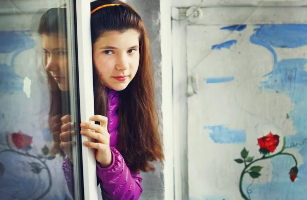 美丽的年轻女孩到窗外阳台上墙 d — 图库照片