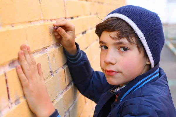 Preteen handsome boy try himself as a graffiti artist on the yel — Stock Photo, Image