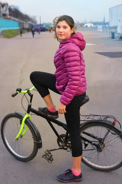 Preteen bella ragazza in giacca alba con bicicletta sul grande ci — Foto Stock