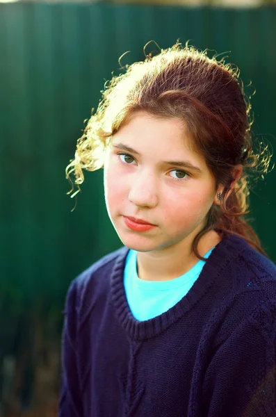 Beautiful preteen girl with brown curly hair in back sun light o — Stock Photo, Image