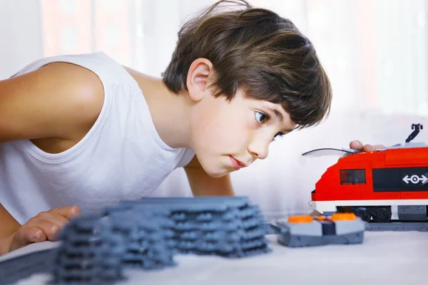 Preteen handsome boy play with meccano toy train and railway sta — Stock Photo, Image