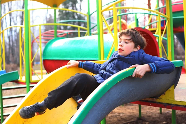 Preteen bel ragazzo sul parco giochi scivolo — Foto Stock