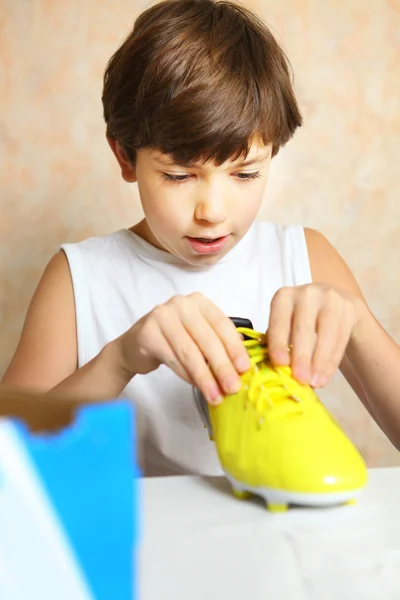 Preteen handsome boy with brand new yellow footbal boot as a bir — Stock Photo, Image