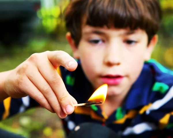 Preteen handsome boy play with fire hold match — Stock Photo, Image