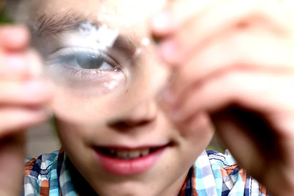 Jongen ontdekken kenmerken op bolle lens — Stockfoto