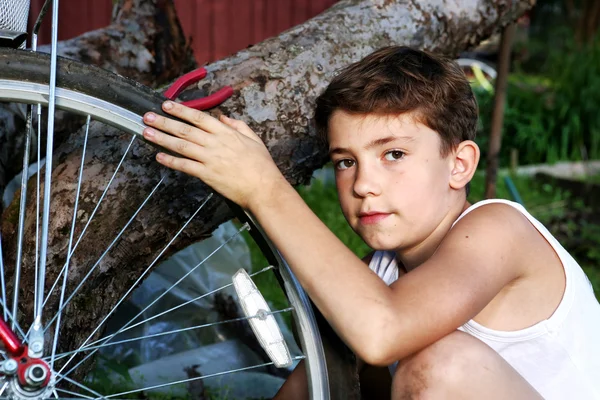 Niedlich preteen junge machen rapairment von seine bisycle — Stockfoto